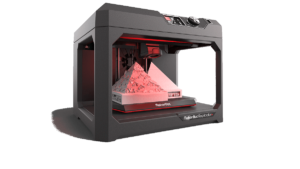 Image of a 3D printer. It has open sides and two pyramid shaped objects in the print area.